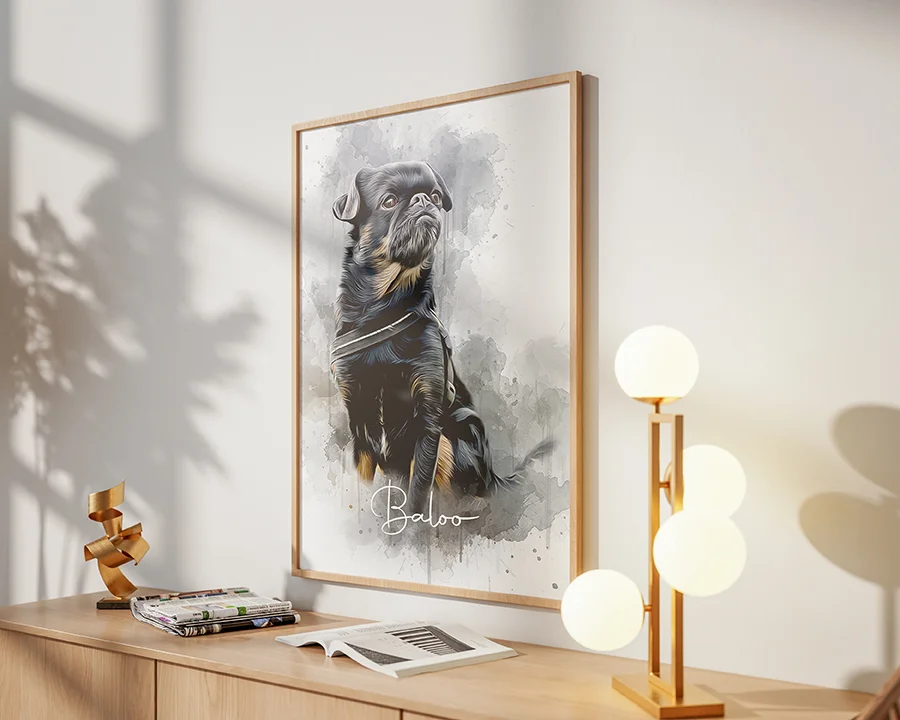 Griffon-hunden Baloo i en stilig akvarellmålning, inramad i en naturfärgad träram ovanför en möbel med böcker, tidningar och en lampa på. Ljuset från ett fönster kommer in från vänster i bild.