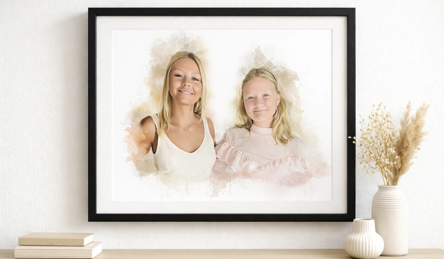 En akvarellmålning i svart träram och vit passpartou. Bilden föreställer två yngre tjejer. Tavlan hänger på väggen i svart träram, ovanför en möbel med vita vaser på.